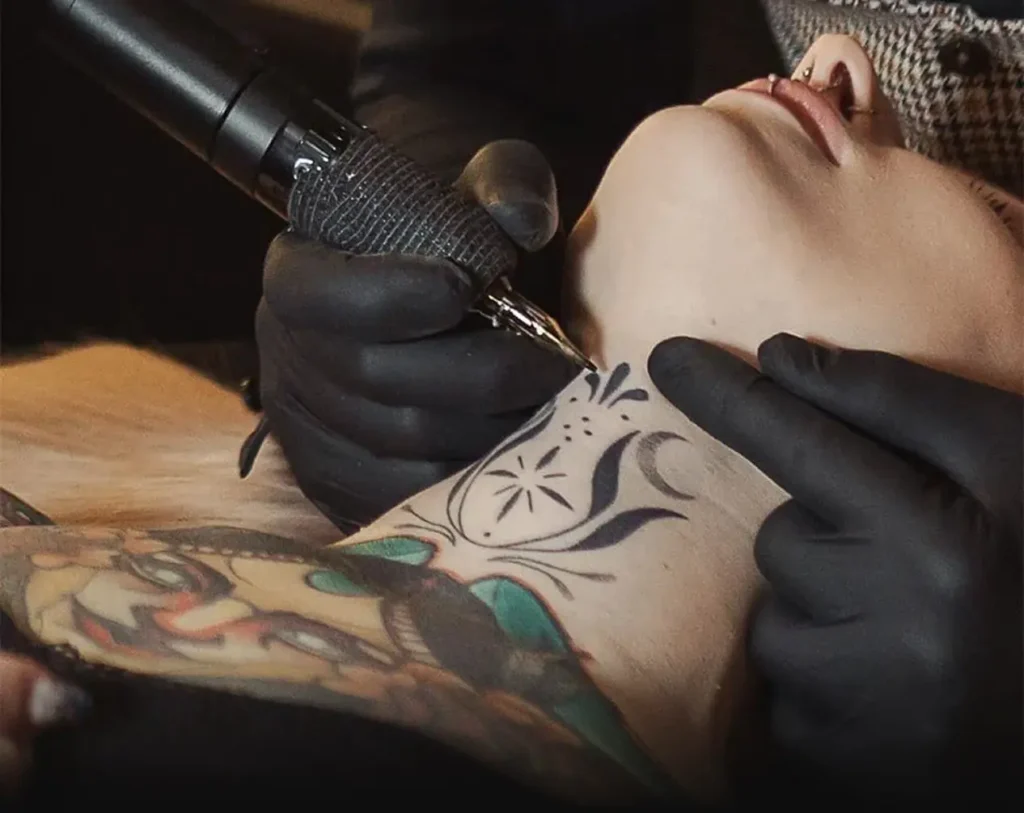 Detailní tetování krku s ornamenty a symbolem měsíce v pražském studiu MagicTattoo.