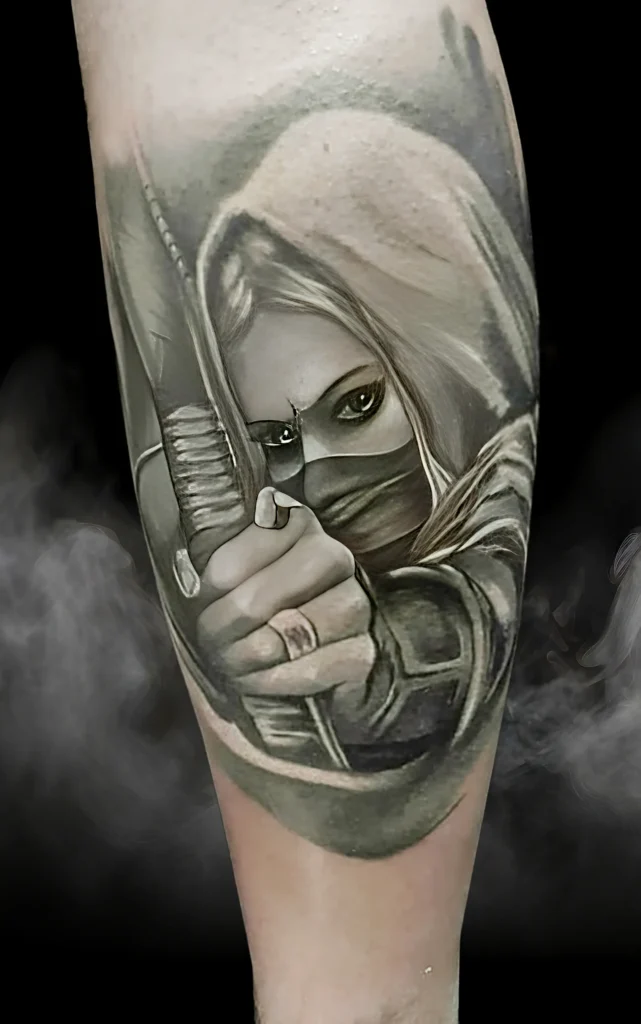 Detailní tetování lukostřelkyně v kapuci s lukem od Michala z pražského studia Magic Tattoo.