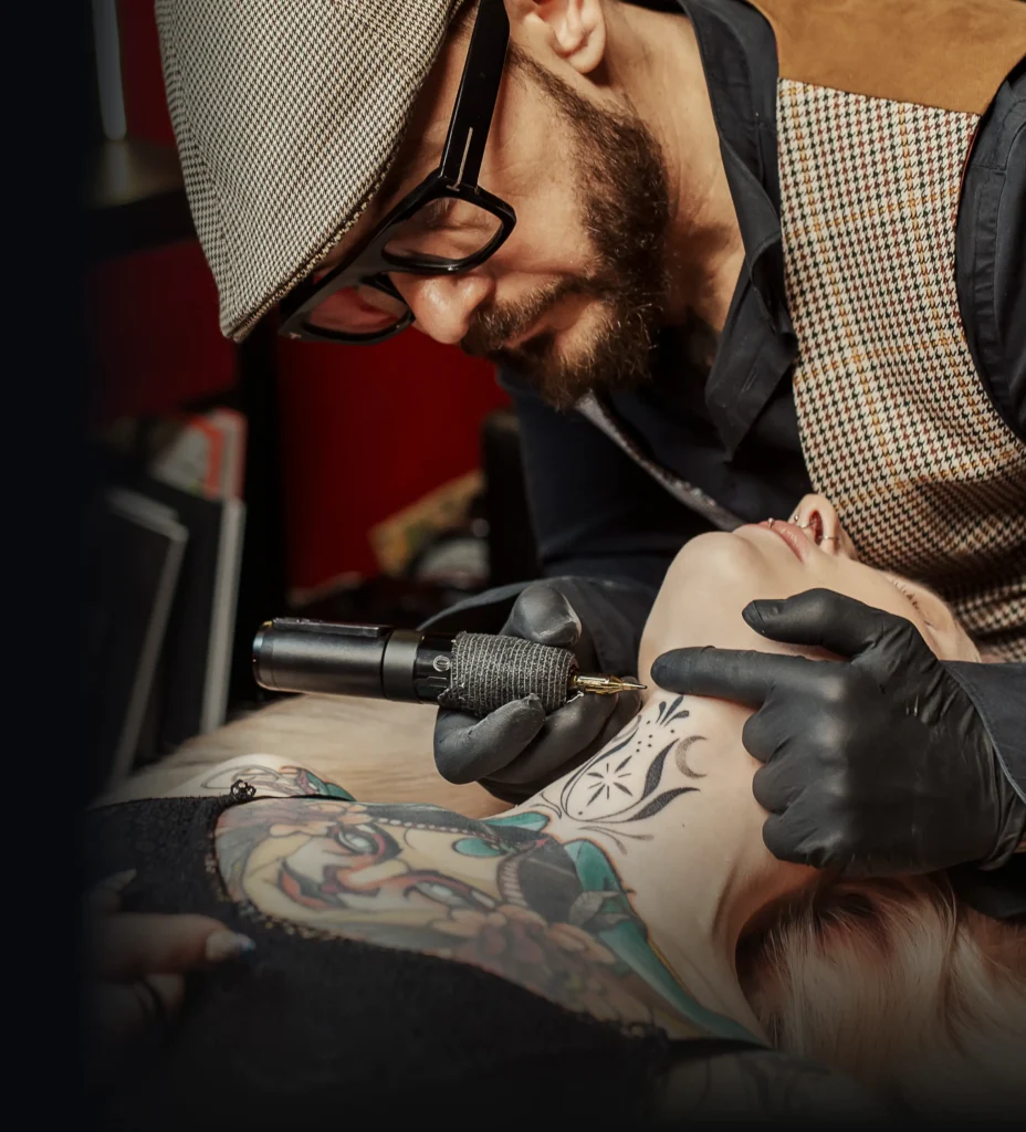 Tatér vytvářející detailní tetování podle požadavku na míru na krku klientky.