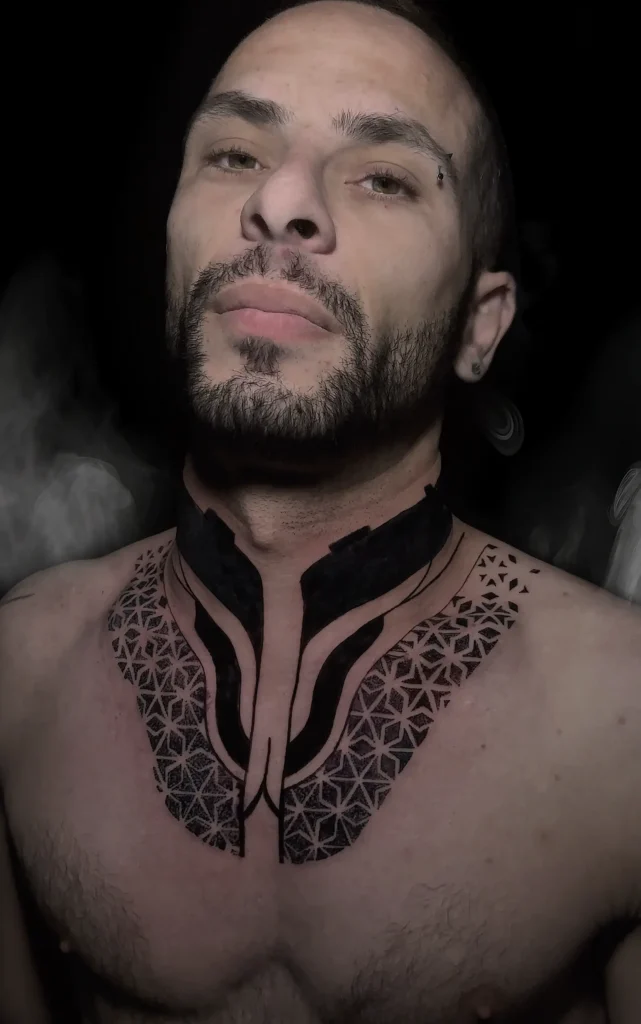 Černé geometrické tetování na krku a hrudi od studia Magic Tattoo v Praze.