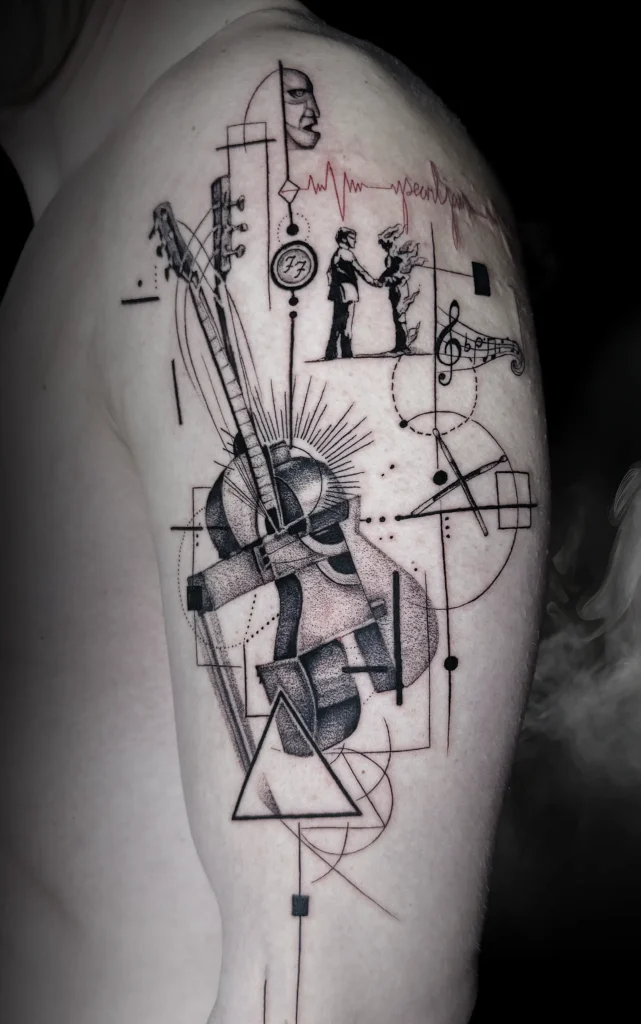 Abstraktní černé tetování s hudebními motivy na rameni vytvořené tatérkou Yanou v Magic Tattoo Praha.