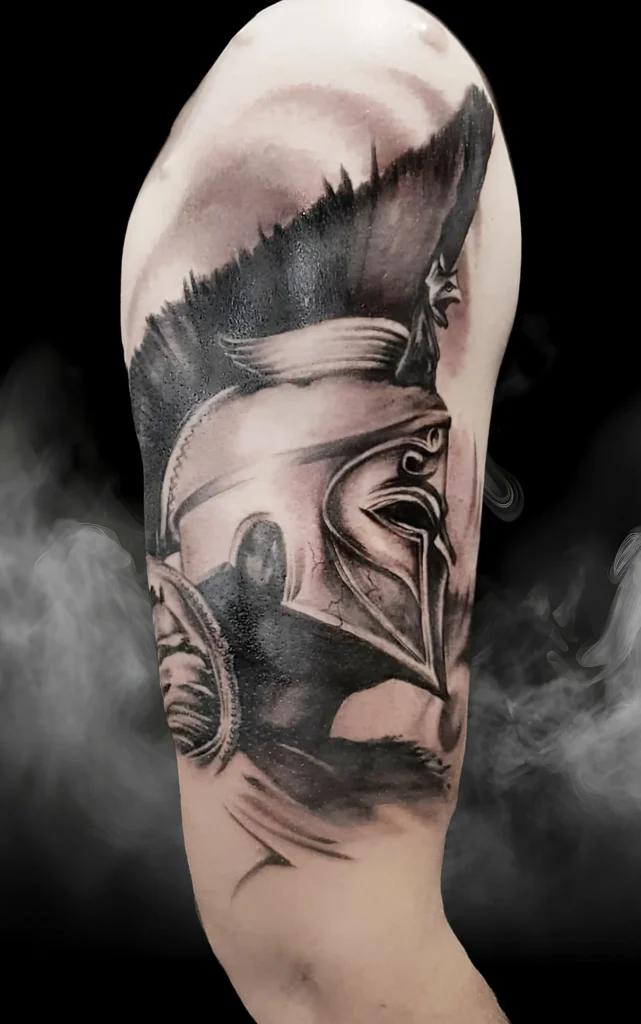 Detailní tetování spartské přilby na rameni od tatéra Michala z Magic Tattoo.