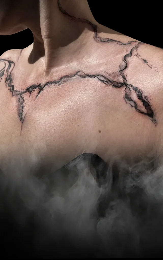 Abstraktní černé tetování na klíční kosti od tatéra MR. K-INK ve studiu Magic Tattoo.