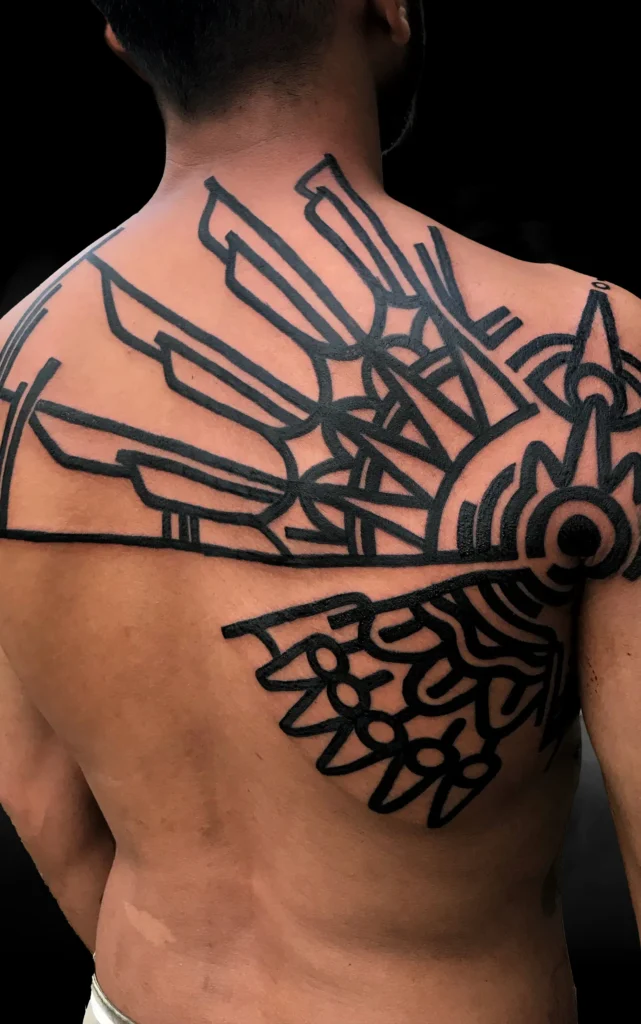 Černé geometrické tetování na horní části zad od tatéra OMKAR v pražském studiu Magic Tattoo.