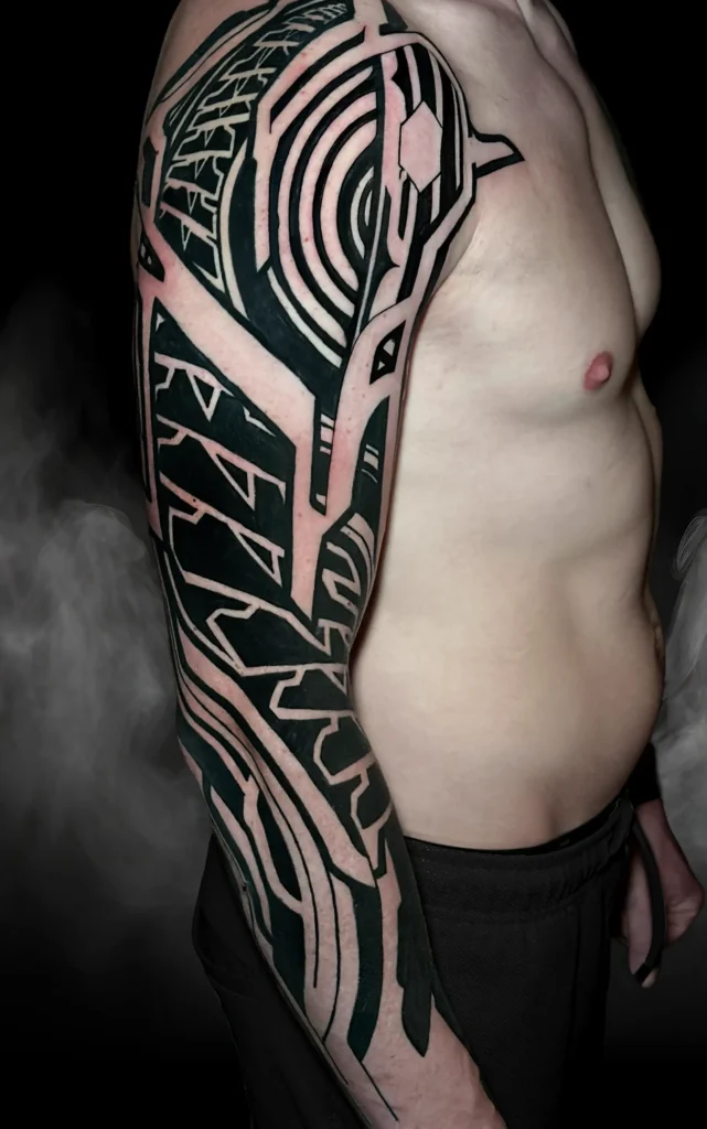 Geometrický blackwork rukáv na celé paži od tatéra OMKAR ze studia Magic Tattoo v Praze.