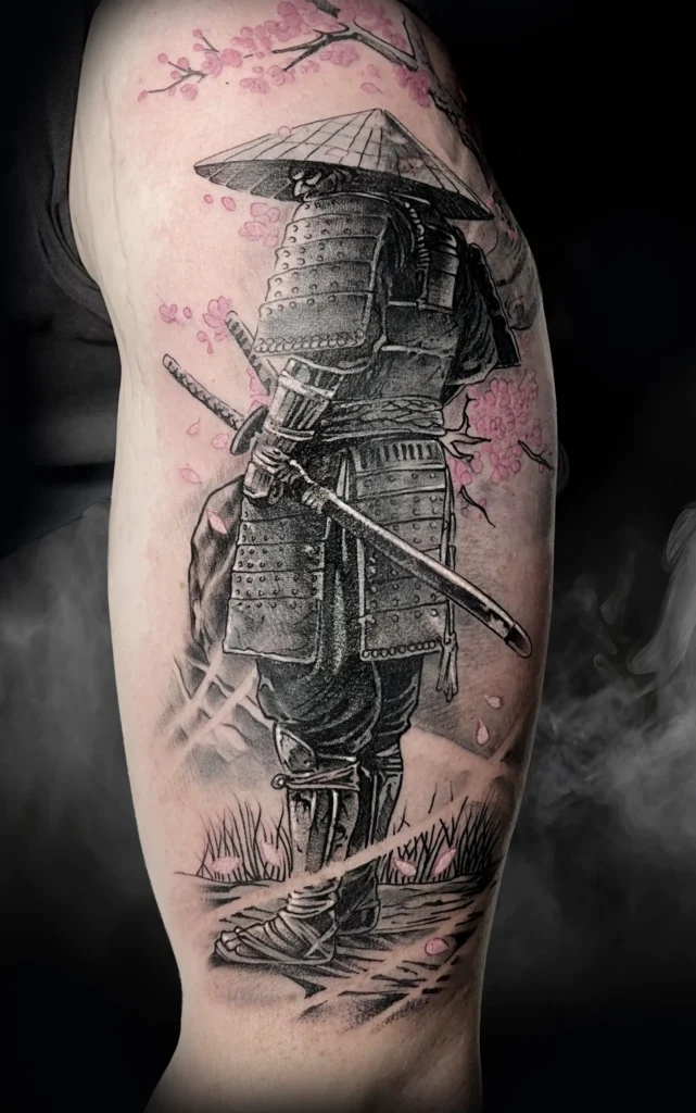 Detailní černé tetování samuraje s motivem růžové sakury od tatéra Pashy.