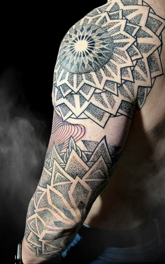 Detailní geometrické dotwork tetování na paži a rameni od tatéra Marka ze studia Magic Tattoo v Praze.